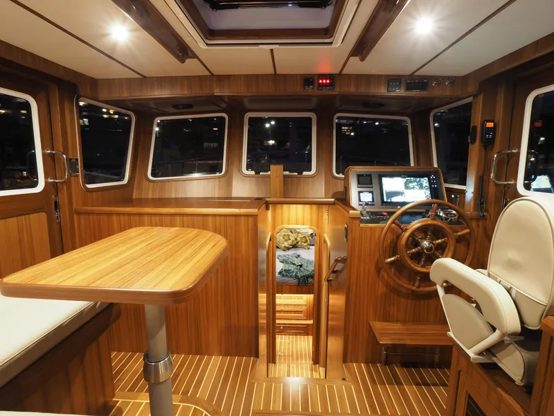 Slide: The Image of Helmsman Trawlers 43E PILOTHOUSE 2026 interior with wood finish and navigation equipment. - 16