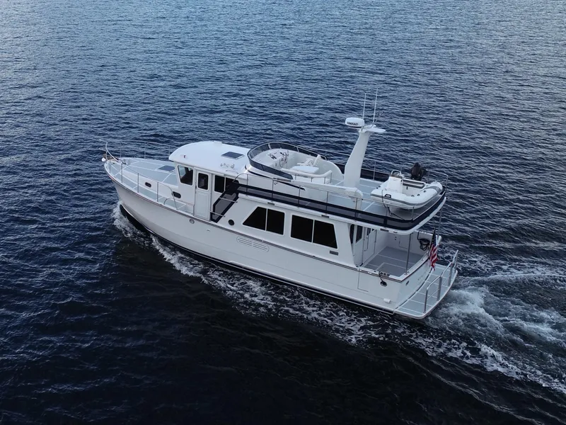 Slide: The Image of 2026 Helmsman Trawlers 43E Pilothouse cruising on open water, side view. - 2