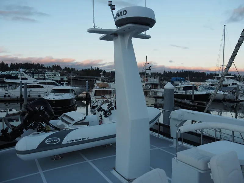 Slide: The Image of Helmsman Trawlers 43E PILOTHOUSE 2026 on deck, featuring radar and inflatable boat at marina. - 35