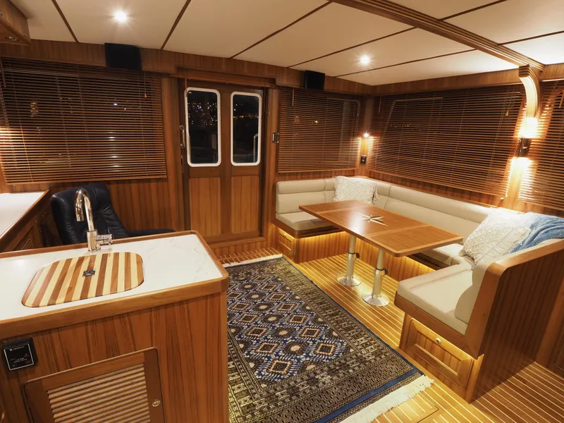 Slide: The Image of Luxurious interior of 2026 Helmsman Trawlers 43E Pilothouse with wood finish and cozy seating. - 5