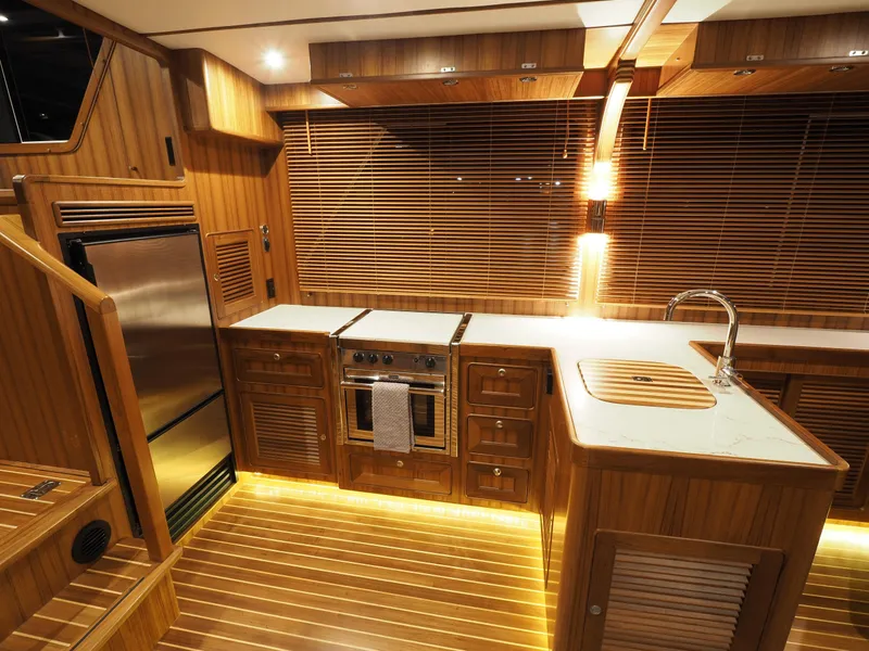Slide: The Image of Luxurious 2026 Helmsman Trawlers 43E Pilothouse kitchen with wood finish and modern appliances. - 6