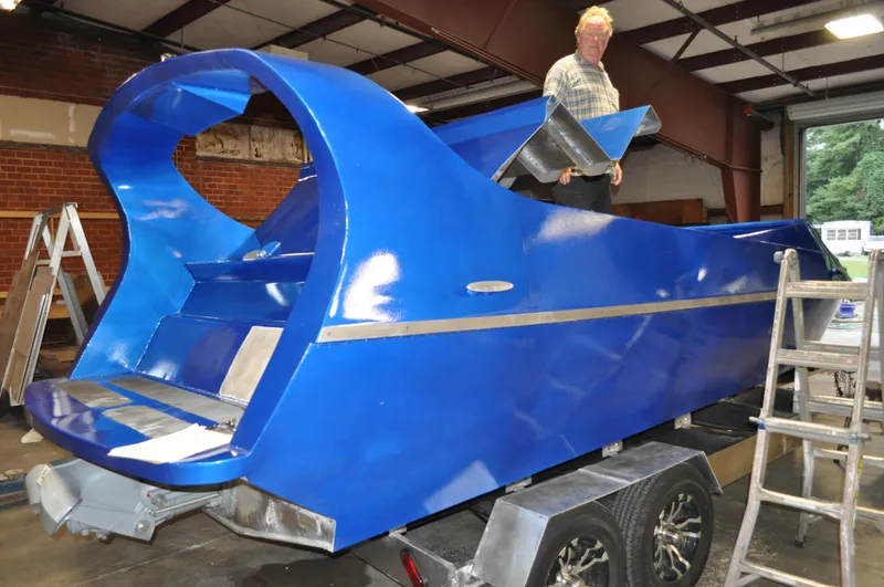 Slide: The Image of 2021 Smoky Mountain 12 Passenger boat in a workshop, vibrant blue finish, on a trailer. - 7