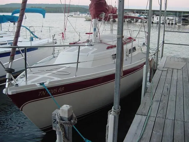 Slide: The Image of 1981 CAL 25II Mk II sailboat docked at a marina with scenic background. - 2