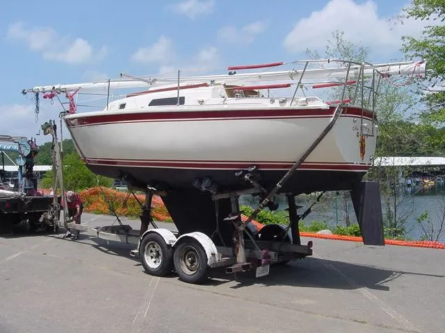 Slide: The Image of 1981 CAL 25II Mk II sailboat on trailer, parked outdoors under a clear sky. - 3