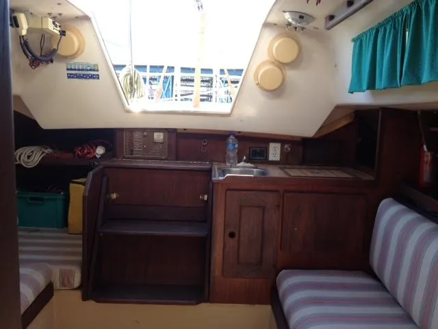 Slide: The Image of Interior of 1981 CAL 25II Mk II sailboat with wood cabinetry and striped seating. - 4