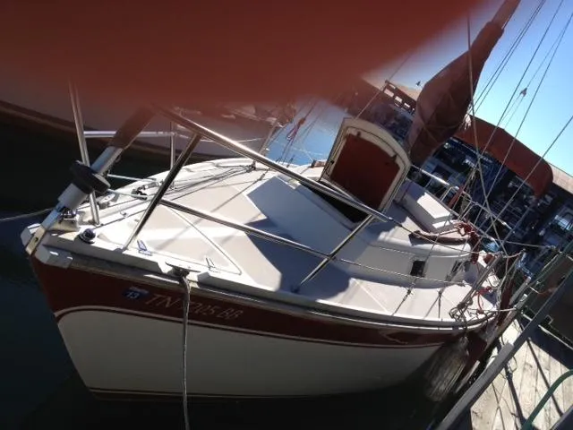 Slide: The Image of 1981 CAL 25II Mk II sailboat docked, featuring sleek design and red accents. - 7