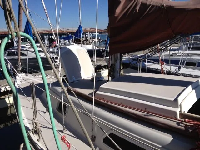 Slide: The Image of 1981 CAL 25II Mk II sailboat docked in marina, surrounded by other boats. - 8