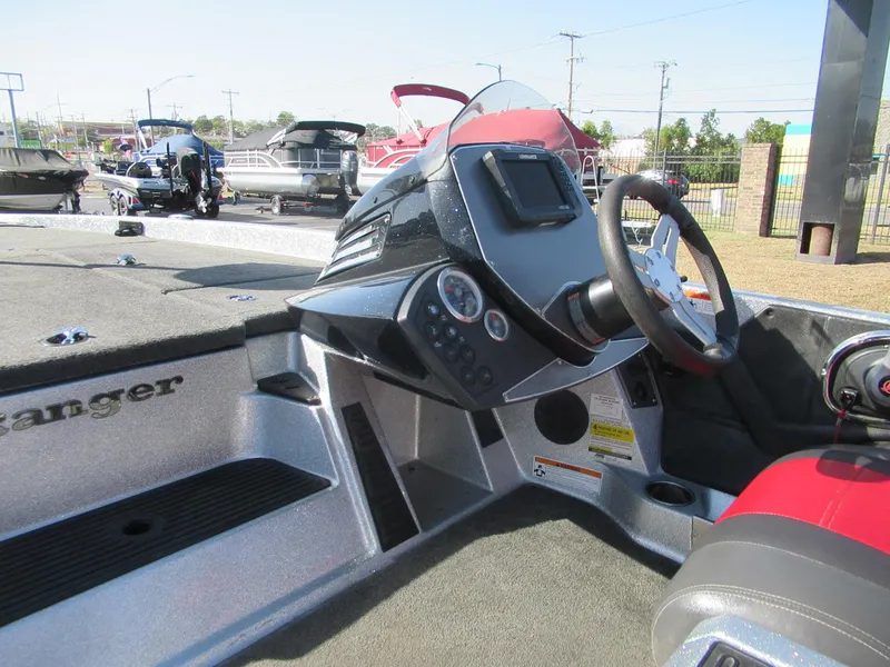 Slide: The Image of 2014 Ranger Z118C boat dashboard with steering wheel and control panel. - 2