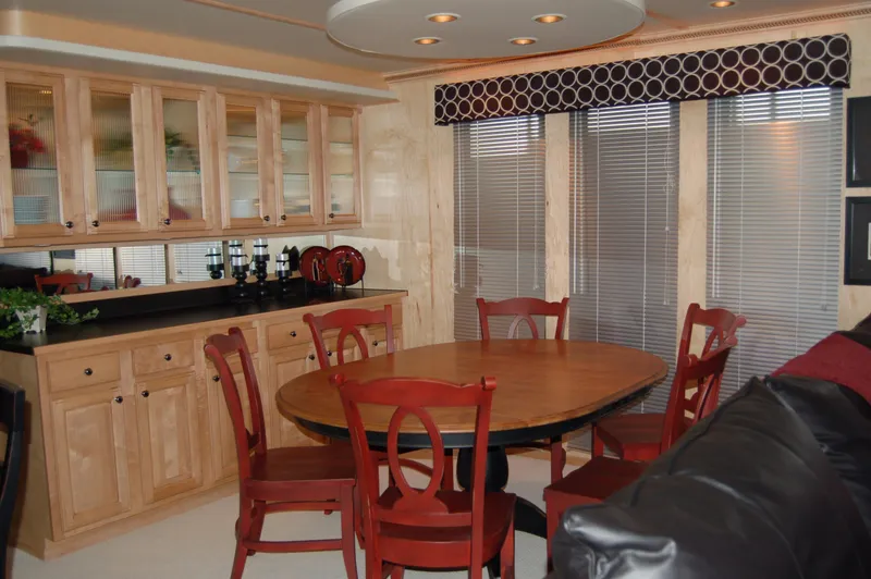 Slide: The Image of Modern dining area in 2006 Sumerset Seas The Day Share 7 houseboat with wooden cabinets and red chairs. - 17