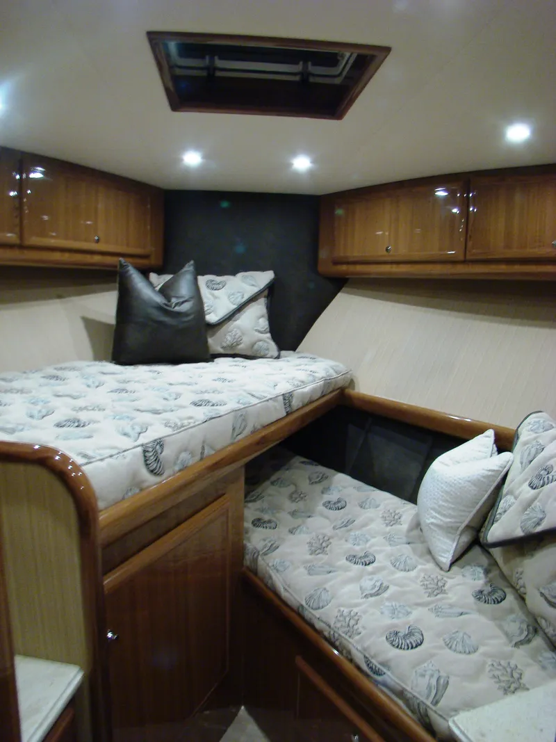 Slide: The Image of 2024 Jersey Cape Devil 45-Express Custom cabin with twin beds and wooden cabinetry. - 24
