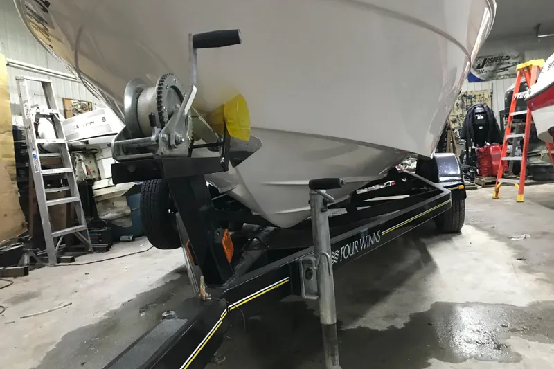 Slide: The Image of 2005 Four Winns 190 Horizon boat on trailer in garage setting. - 11