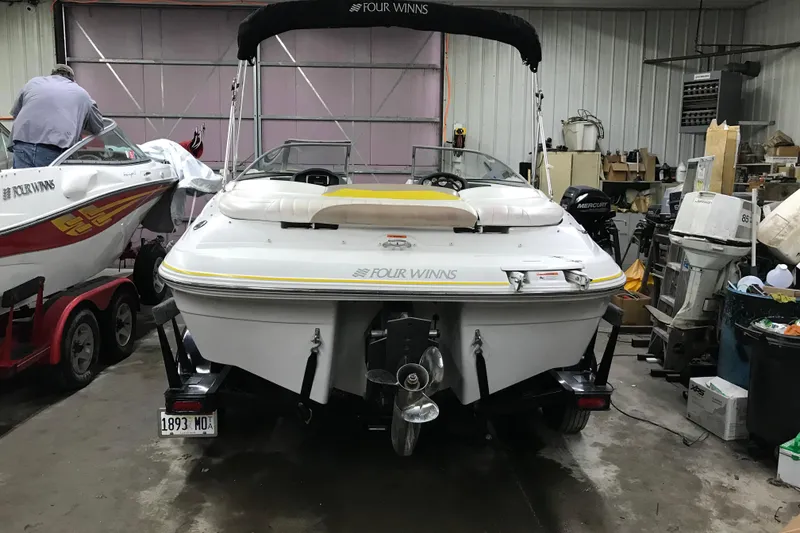 Slide: The Image of 2005 Four Winns 190 Horizon boat in a garage, rear view with outboard motor. - 13