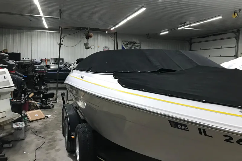 Slide: The Image of 2005 Four Winns 190 Horizon boat covered in a garage with equipment. - 30
