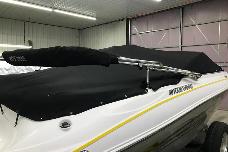 Slide: The Image of 2005 Four Winns 190 Horizon boat with black cover in a garage setting. - 31