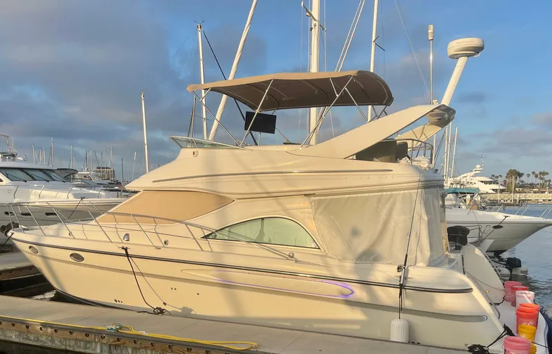 The Image of 1998 Maxum 4100 SCA yacht docked at marina under cloudy sky. - 1