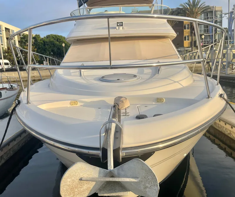 Slide: The Image of 1998 Maxum 4100 SCA yacht docked, front view with anchor and railing. - 5