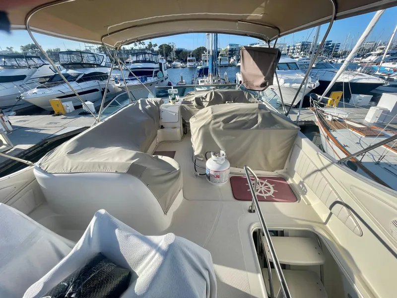 Slide: The Image of 1998 Maxum 4100 SCA yacht interior with covered seating, docked at a marina. - 8