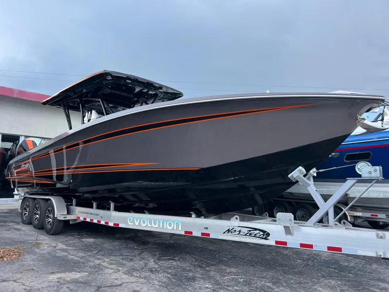 The Image of 2026 Nor-Tech 340 Sport boat on trailer, sleek design with orange accents. - 0