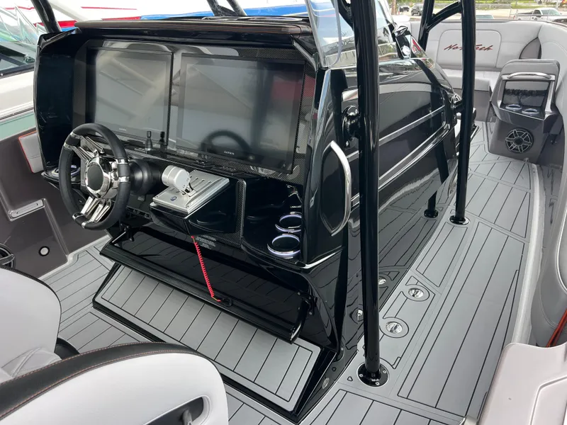 Slide: The Image of 2026 Nor-Tech 340 Sport boat interior with sleek dashboard and modern steering wheel. - 13
