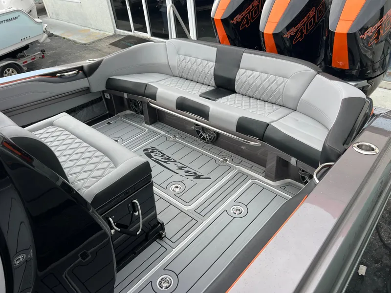 Slide: The Image of 2026 Nor-Tech 340 Sport boat interior with gray quilted seating and powerful engines. - 22
