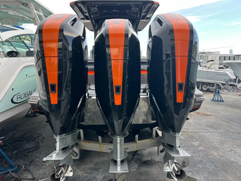 Slide: The Image of Triple outboard motors on a 2026 Nor-Tech 340 Sport boat, featuring sleek black and orange design. - 4