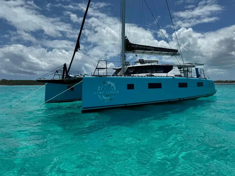 Slide: The Image of Vision 444 ES 2025 catamaran sailing on clear turquoise waters under a cloudy sky. - 13