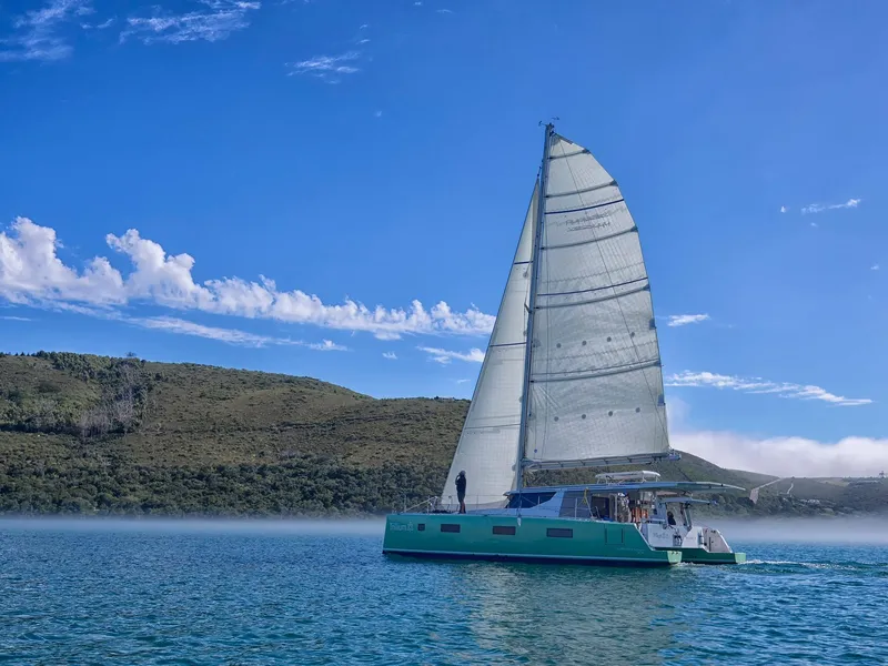 Slide: The Image of Sailing catamaran Vision 444 ES 2026 on serene lake with clear blue sky. - 5