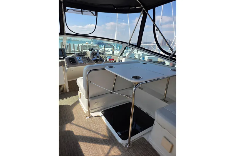 Slide: The Image of 1997 Carver 350 Mariner cockpit with steering wheel, seating, and table under canopy. - 17