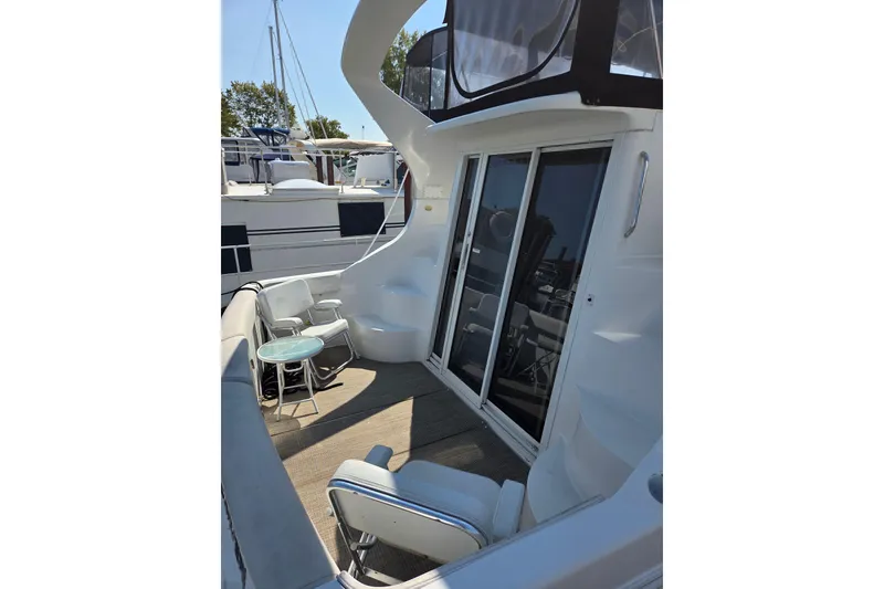 Slide: The Image of 1997 Carver 350 Mariner yacht deck with seating and glass doors. - 21