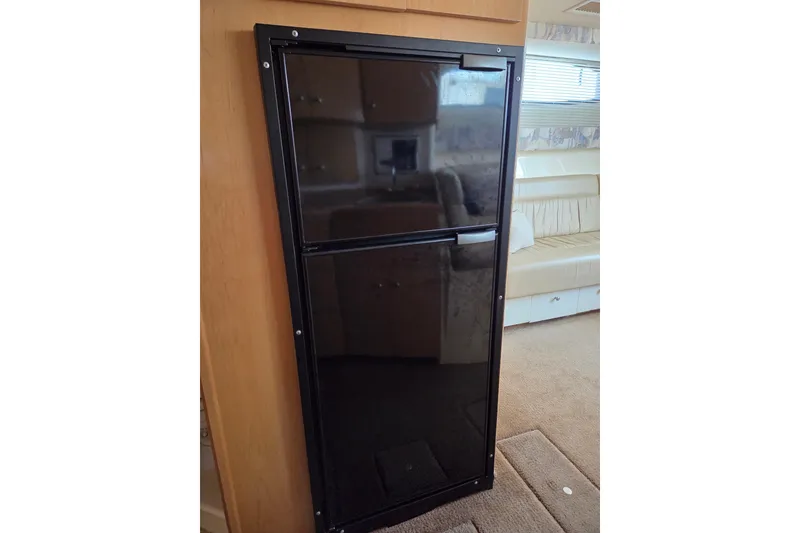 Slide: The Image of Black refrigerator inside 1997 Carver 350 Mariner yacht, with beige interior. - 31