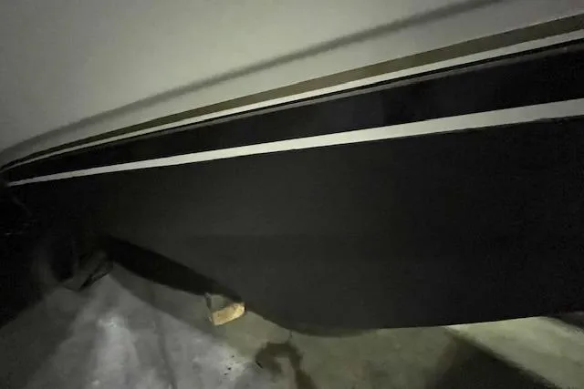 Slide: The Image of 1997 Carver 350 Mariner boat hull with black and white stripes in a dimly lit area. - 43