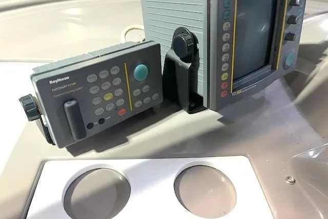 Slide: The Image of 1997 Carver 350 Mariner dashboard with Raytheon navigation equipment and cup holders. - 11