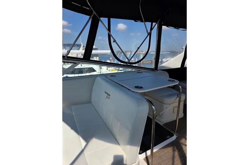 Slide: The Image of 1997 Carver 350 Mariner interior with seating and table, featuring marina view. - 16