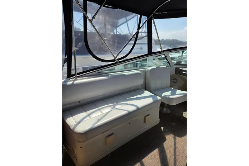 Slide: The Image of 1997 Carver 350 Mariner interior with white seating and canopy, showcasing luxury boat design. - 18