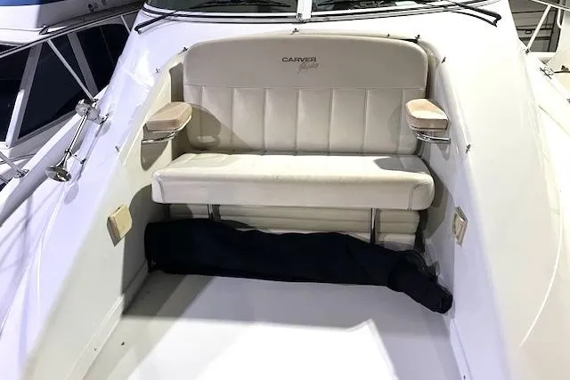 Slide: The Image of 1997 Carver 350 Mariner boat seating area with cushioned bench and armrests. - 23
