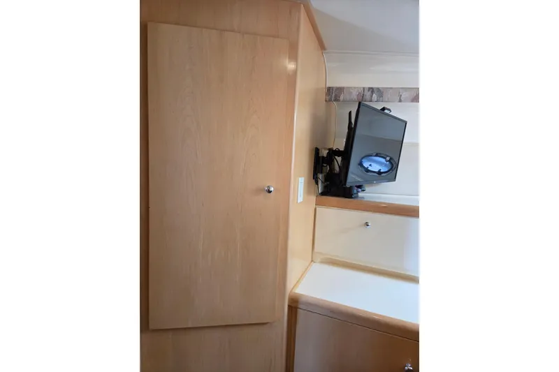 Slide: The Image of Interior of 1997 Carver 350 Mariner with wooden cabinetry and mounted TV. - 33