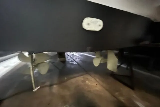 Slide: The Image of 1997 Carver 350 Mariner boat propellers and hull in a dry dock setting. - 40