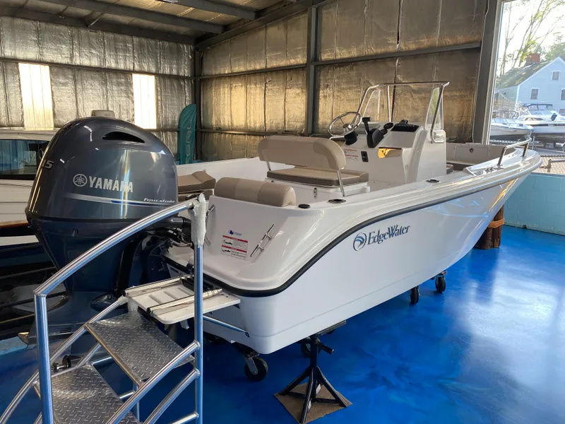 Slide: The Image of 2026 Edgewater 170CC boat displayed indoors with Yamaha engine, snowy outdoor view. - 1