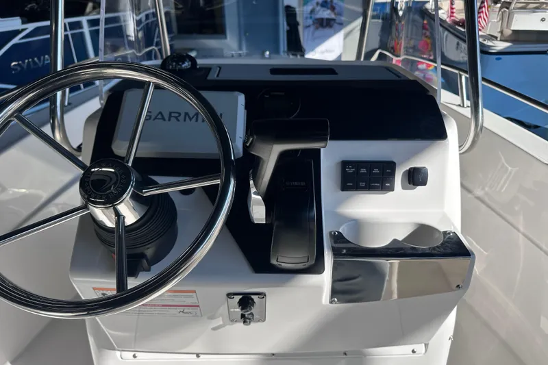 Slide: The Image of 2026 Edgewater 170CC boat console with steering wheel and Garmin navigation system. - 18