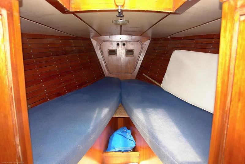 Slide: The Image of Interior cabin of 1973 Nautor Swan 44 sailboat with wooden paneling and blue cushions. - 11