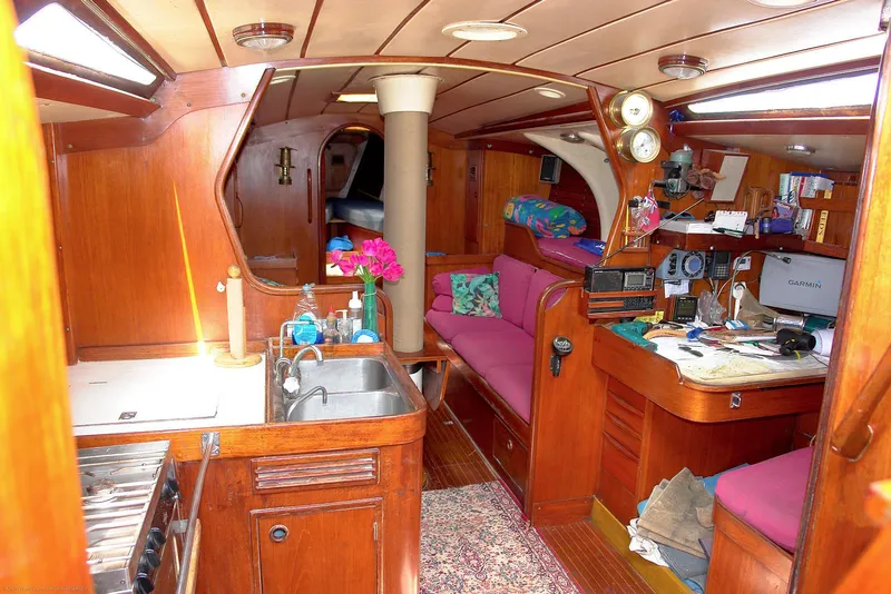Slide: The Image of Interior of a 1973 Nautor Swan 44 yacht with wooden furnishings and pink seating. - 19