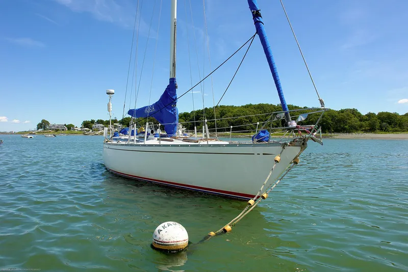 Slide: The Image of 1973 Nautor Swan 44 sailboat anchored in calm waters under a clear blue sky. - 28