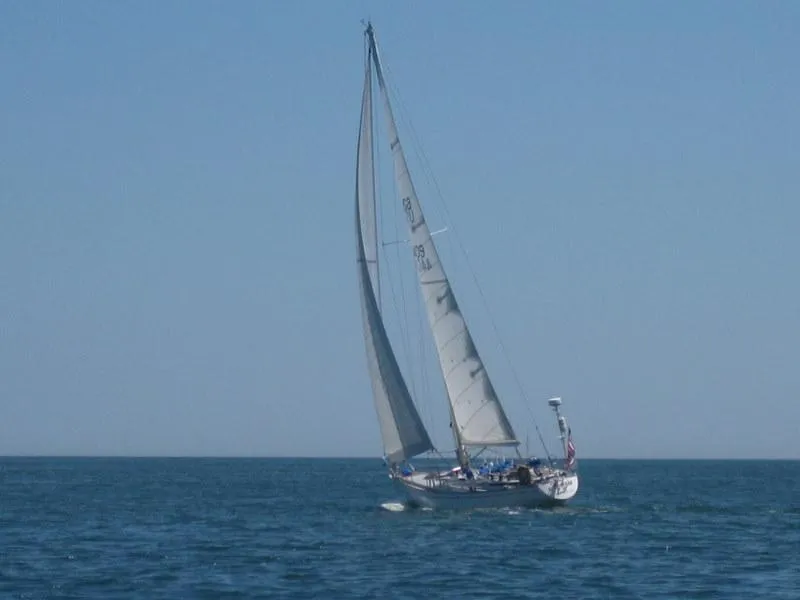 Slide: The Image of Vintage 1973 Nautor Swan 44 sailing on open sea under clear blue sky. - 30
