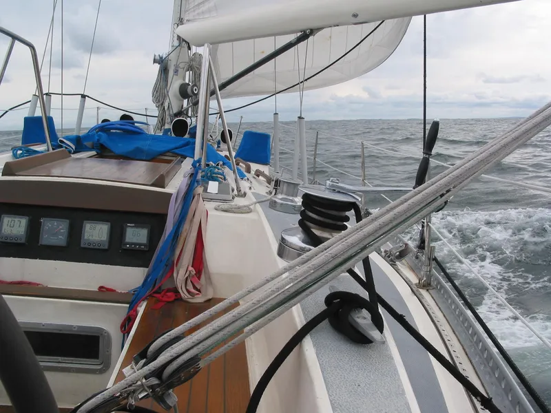Slide: The Image of 1973 Nautor Swan 44 sailboat navigating through choppy waters under cloudy skies. - 31