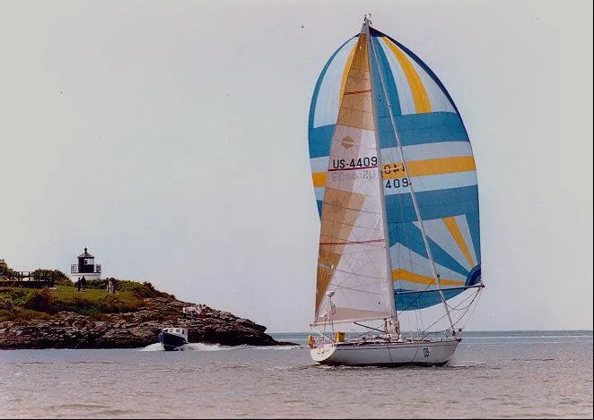 Slide: The Image of 1973 Nautor Swan 44 sailboat with colorful spinnaker near a lighthouse. - 32