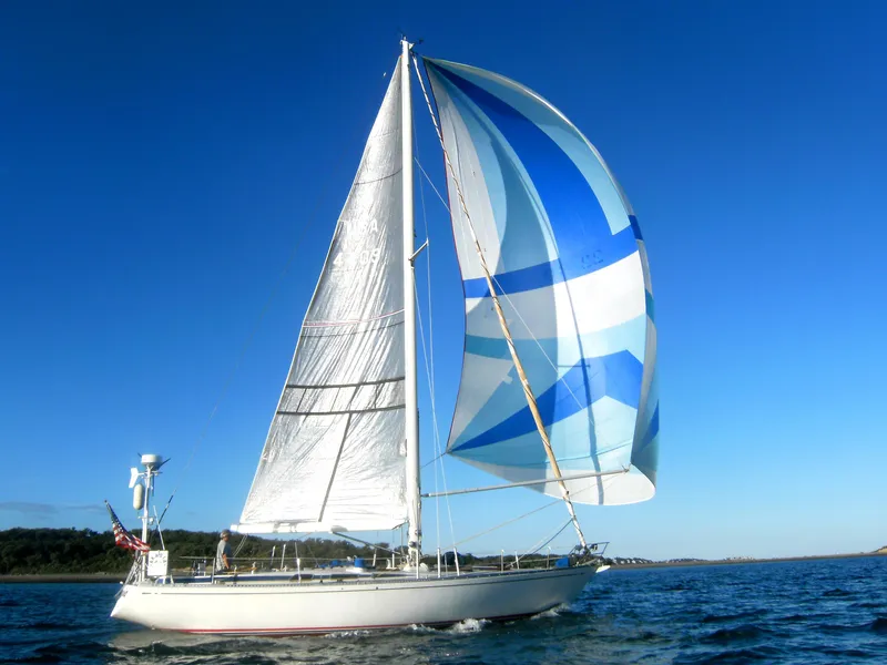 Slide: The Image of 1973 Nautor Swan 44 sailboat with colorful spinnaker on open water. - 4