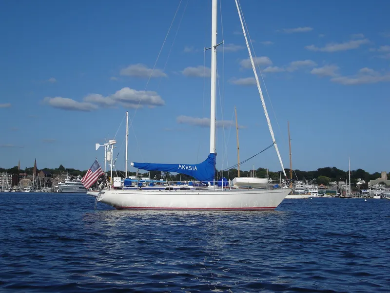 Slide: The Image of 1973 Nautor Swan 44 sailboat on calm water with blue sky and distant shoreline. - 8