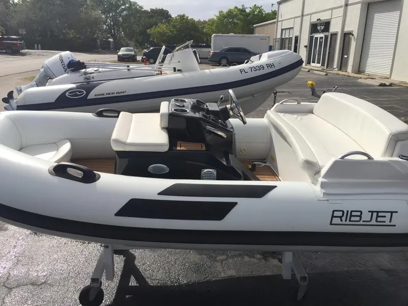 Slide: The Image of 2023 Ribjet 10 inflatable boat with white seating and control console. - 2