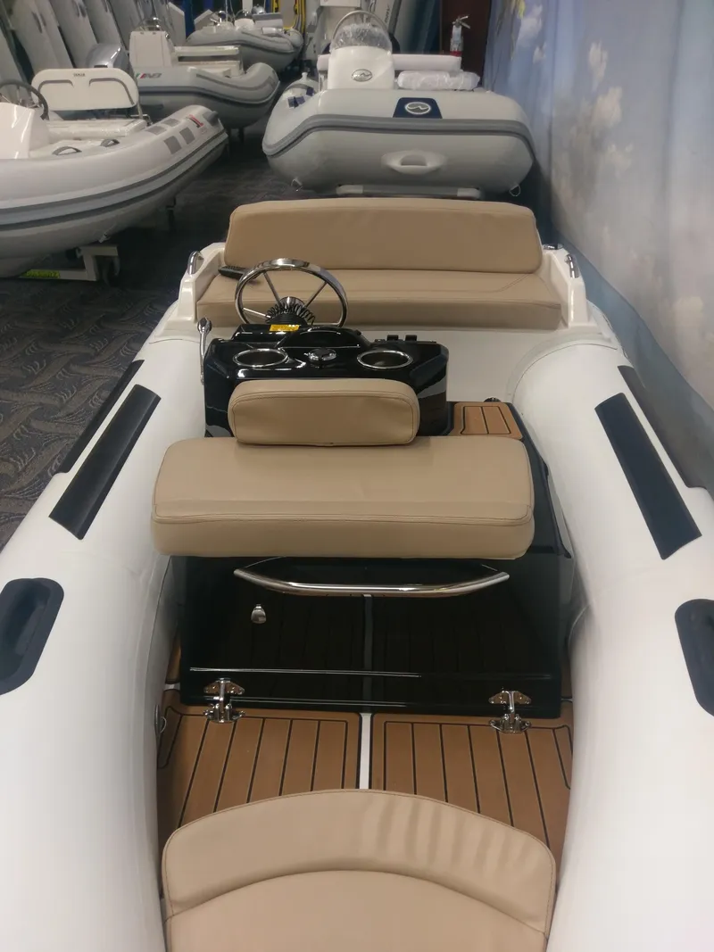Slide: The Image of 2023 Ribjet 10 inflatable boat with beige seating and wooden flooring. - 3