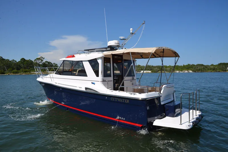 Slide: The Image of 2016 Cutwater C26 boat cruising on a sunny day, featuring a sleek design and canopy. - 0